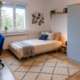 Möbliertes Wohnheimzimmer in Geislingen mit Bett, Schreibtisch, Kleiderschrank und Fenster.