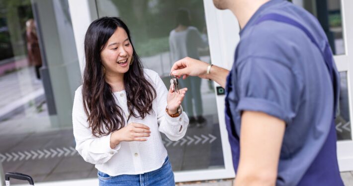 Schlüsselübergabe an eine Studentin